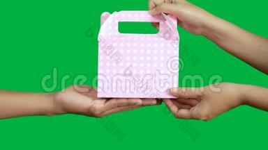 4K. 人们手送和取粉红点礼盒包装隔离在色度键绿色屏幕背景上